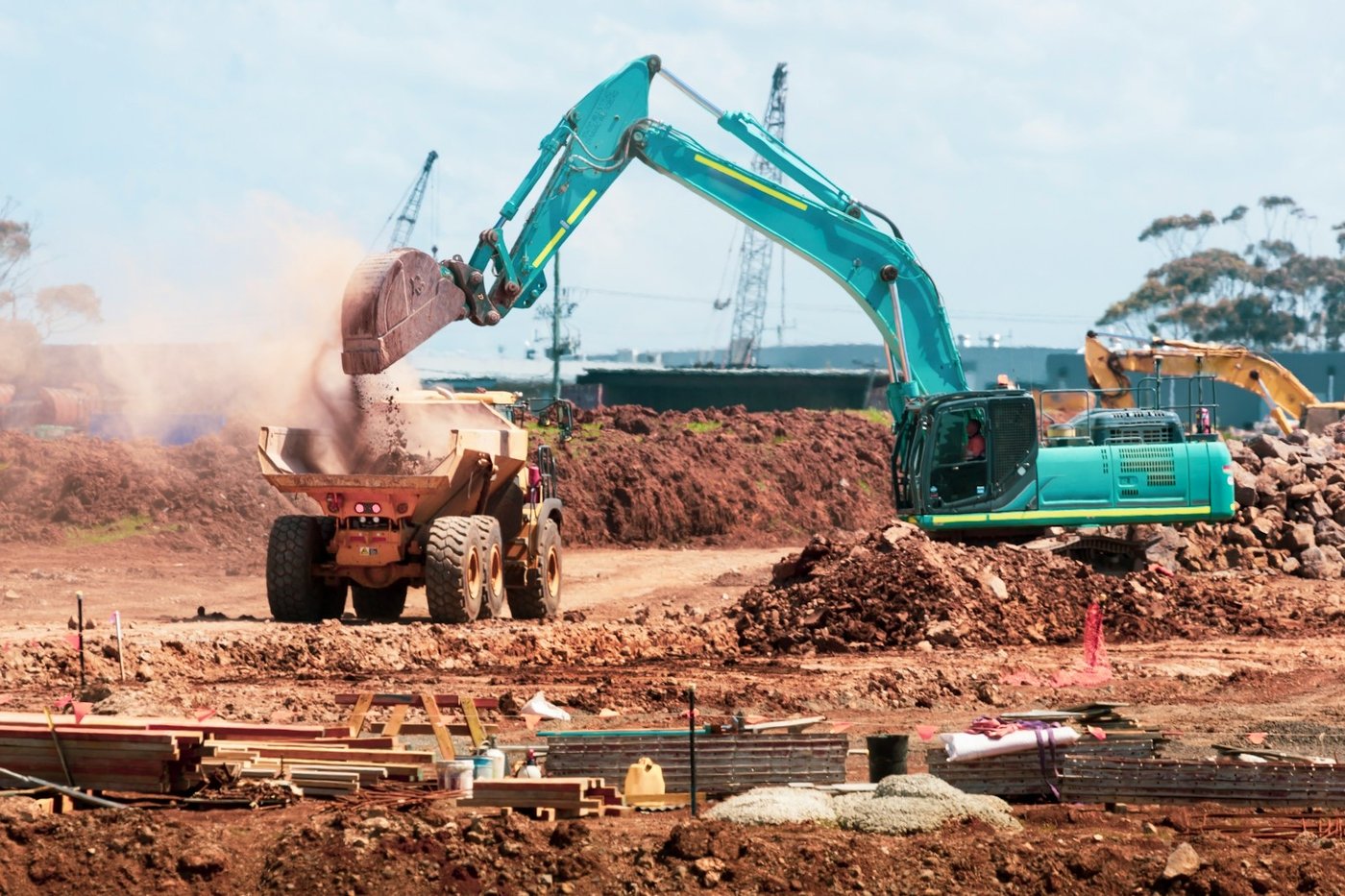 An excavator loading a dump truck on a construction site
