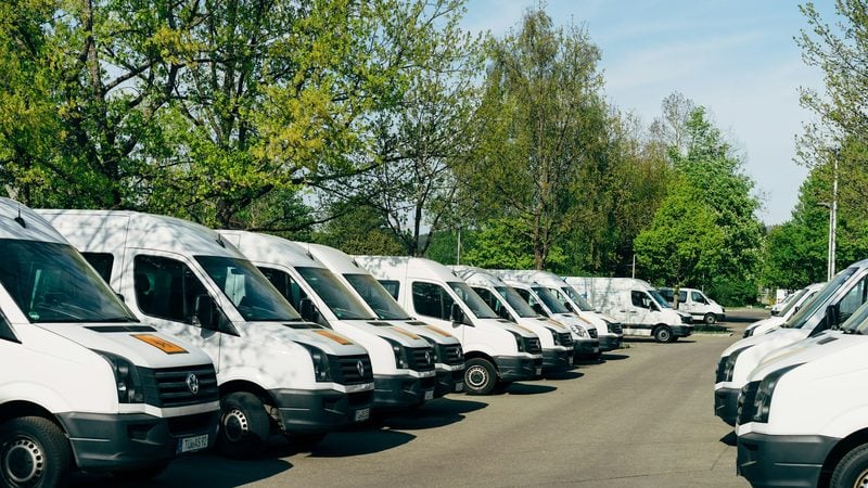 Row of light commercial vans parked at a council depot