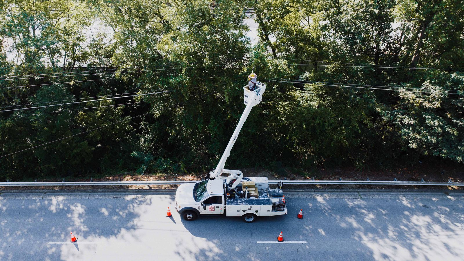 Linemen working from a bucket truck at a utility pole